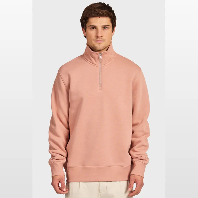 Man wearing a dusty rose Academy 1/4 Zip Sweat with a mock neck and silver zipper.