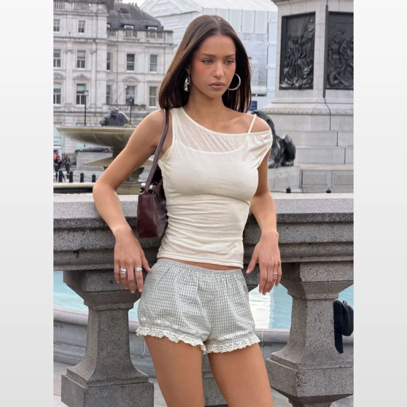 Woman wearing a cream-coloured Skaia layered sheer top with an asymmetrical, off-shoulder neckline and a cami-style lining.