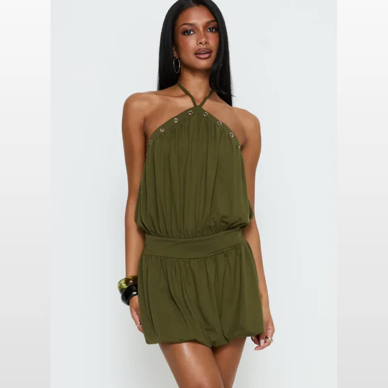Woman wearing a green Sunnee Eyelet Detail Romper with a halter neckline, ruched elasticated waist, and built-in shorts.