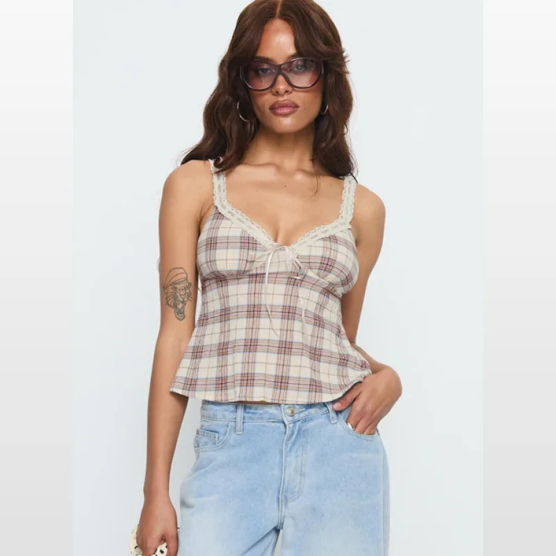 Woman wearing a beige check print camisole top with lace trim and a tie detail at the bust.