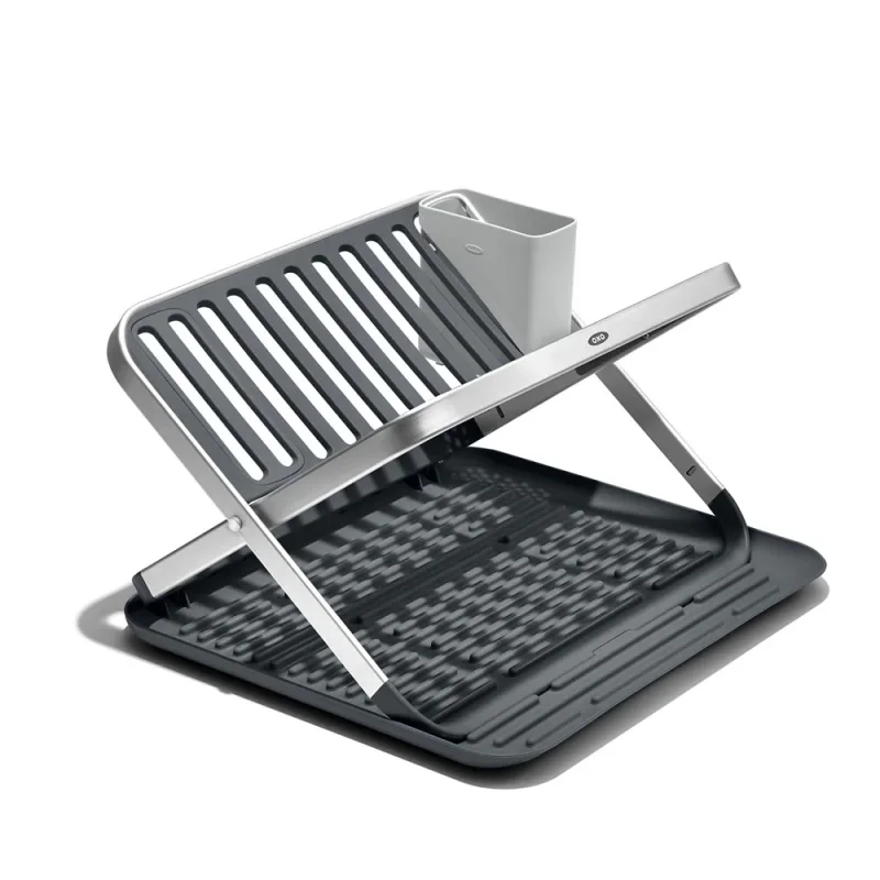 OXO Fold Flat Drying Rack with a rustproof aluminium frame and grey plastic draining tray and utensil cup.