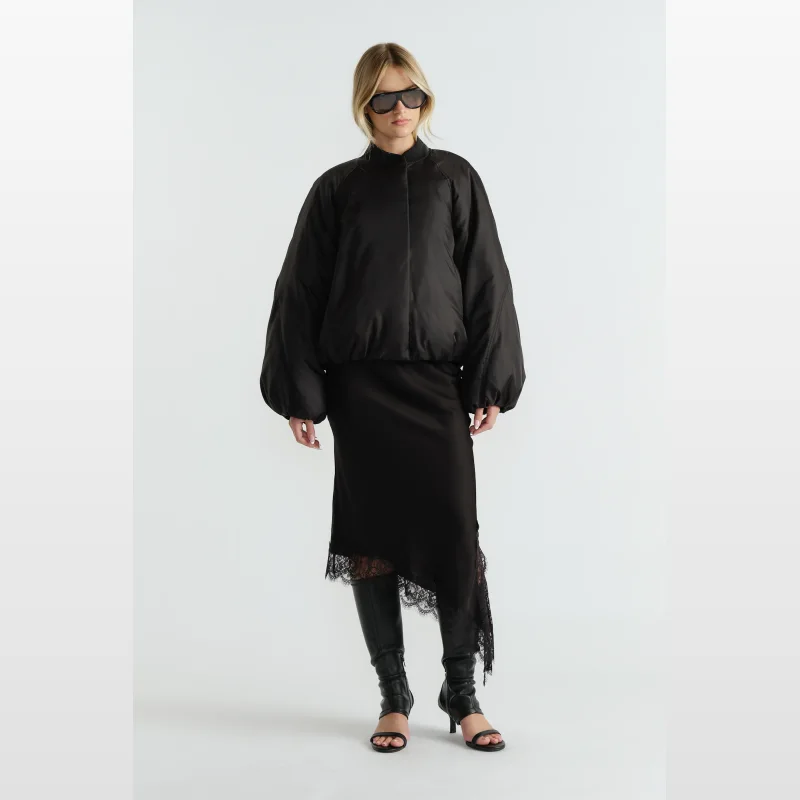 Woman wearing a black Oakley oversized bomber jacket with balloon sleeves and a collared neckline.