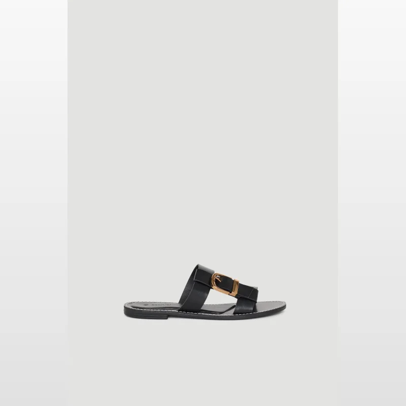 Black Decjuba Cassie Buckle flat sandal with a gold buckle detail and round open toe.