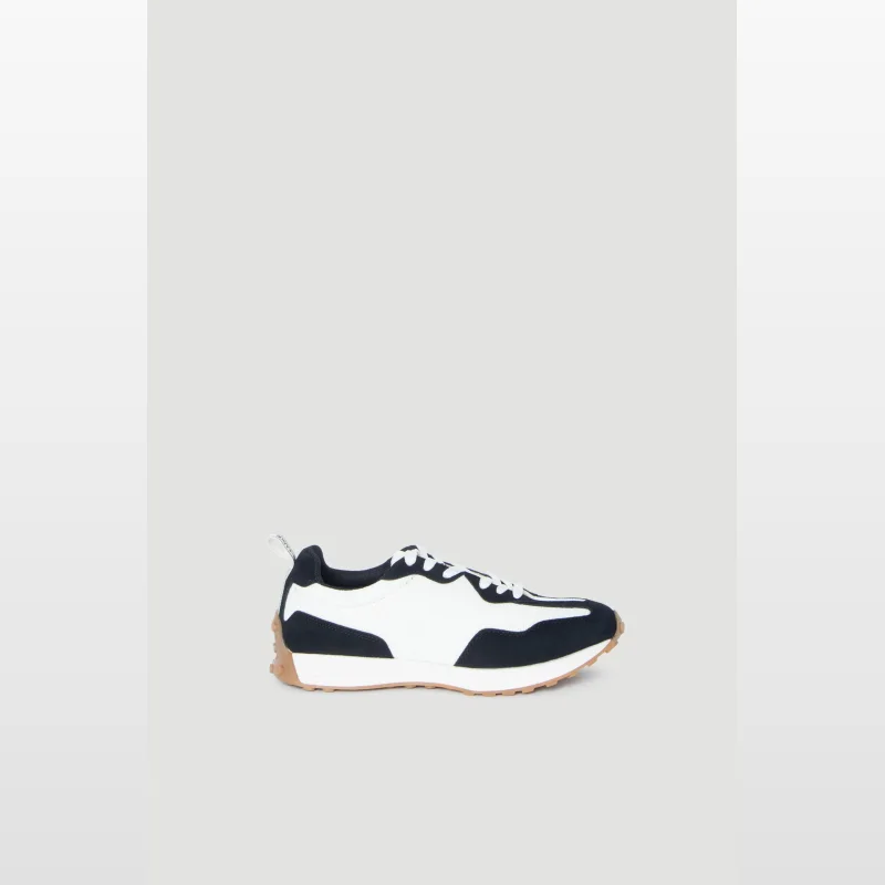 Side view of a Decjuba D-Luxe Mila Sneaker in navy and white with a gum sole.