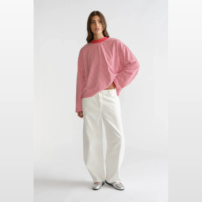 Woman wearing a red and white striped long sleeve t-shirt with wide sleeves and white wide-leg jeans.