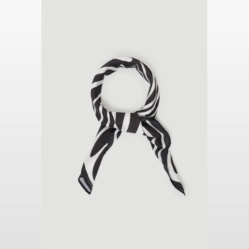 A black and white striped Polly scarf tied in a knot, displayed on a plain grey background.