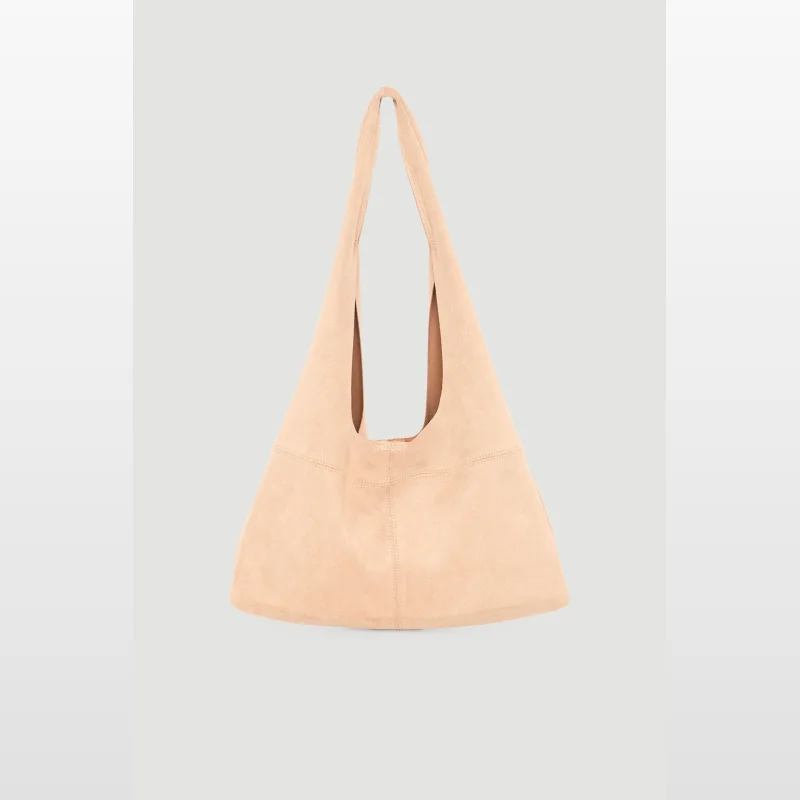 A light tan, slouchy tote bag with a suede-like texture and a magnetic closure, presented against a neutral grey background.