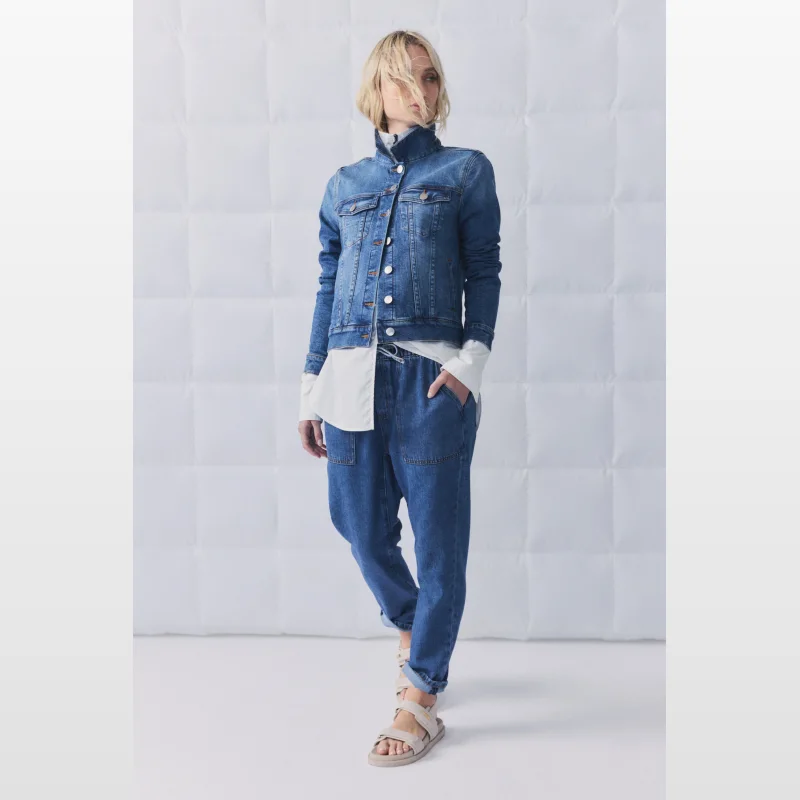 Woman wearing Decjuba D-Luxe Relaxed Denim Joggers with a white shirt and denim jacket.