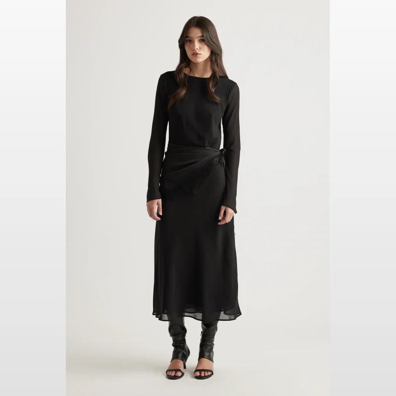 Model wearing a black Decjuba Chelsea Georgette Maxi Dress with long sleeves and an adjustable waist tie.