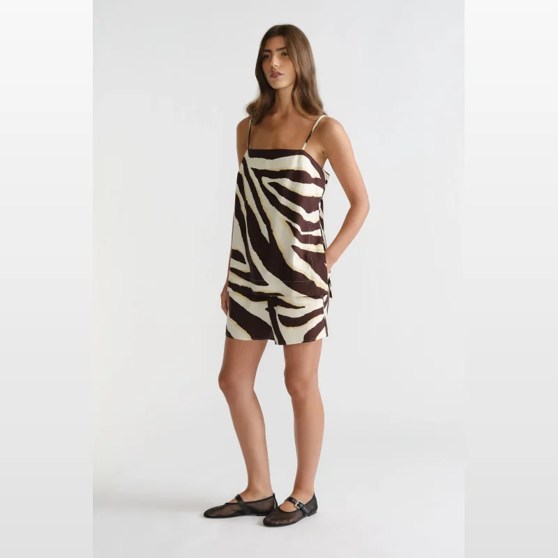 Woman wearing Decjuba elasticated waist shorts with a zebra print in brown, cream, and white, featuring side pockets and a matching camisole.