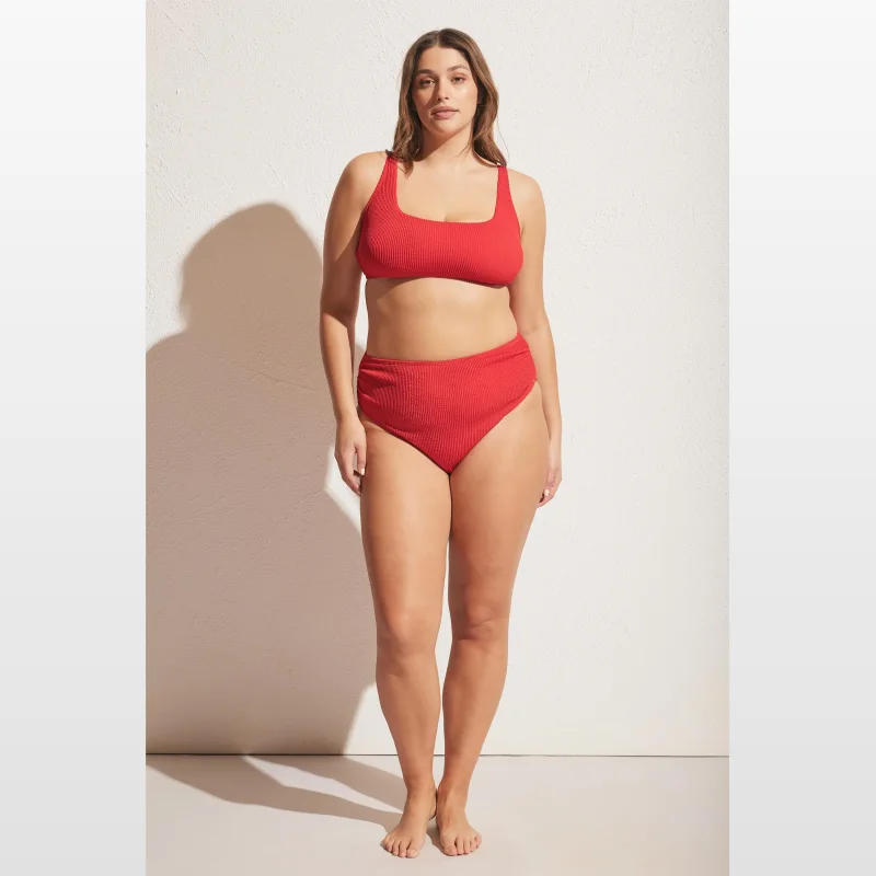Woman wearing a red crinkle bikini top with a square neckline and adjustable straps.