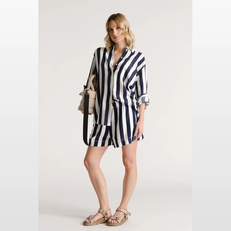 Woman wearing navy and white striped linen blend shorts with an elasticated waistband and drawstring.