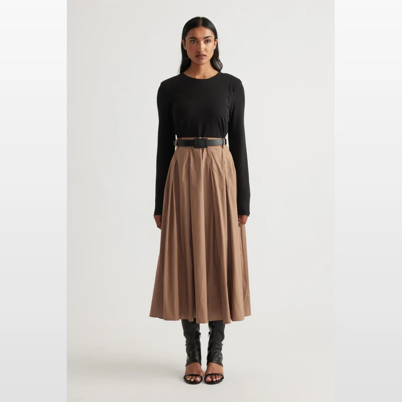 Model wearing the Decjuba Sloane Long Sleeve Midi Dress, featuring a black long-sleeved top and a brown pleated midi skirt with a black contrast belt.