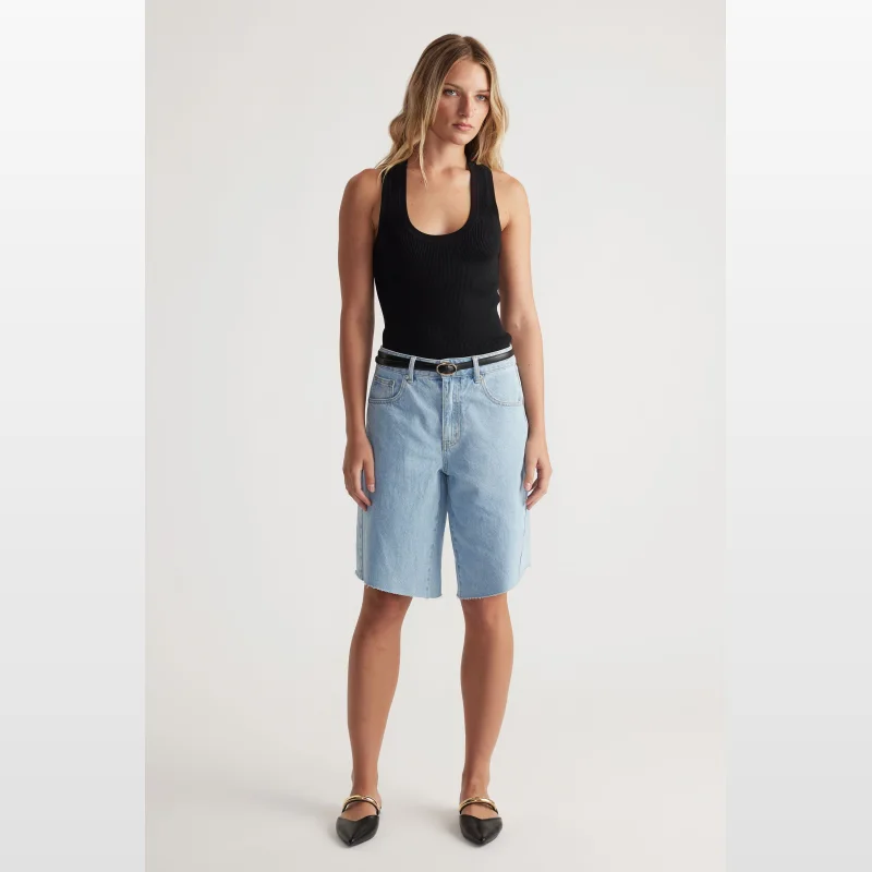 Woman wearing a black ribbed knit Mia Racer Back Knit Tank with a scoop neck and racer back.