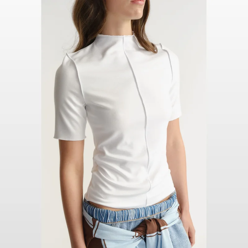 Close-up of a woman wearing a white D-Luxe short sleeve mock neck top with a centre front seam detail.