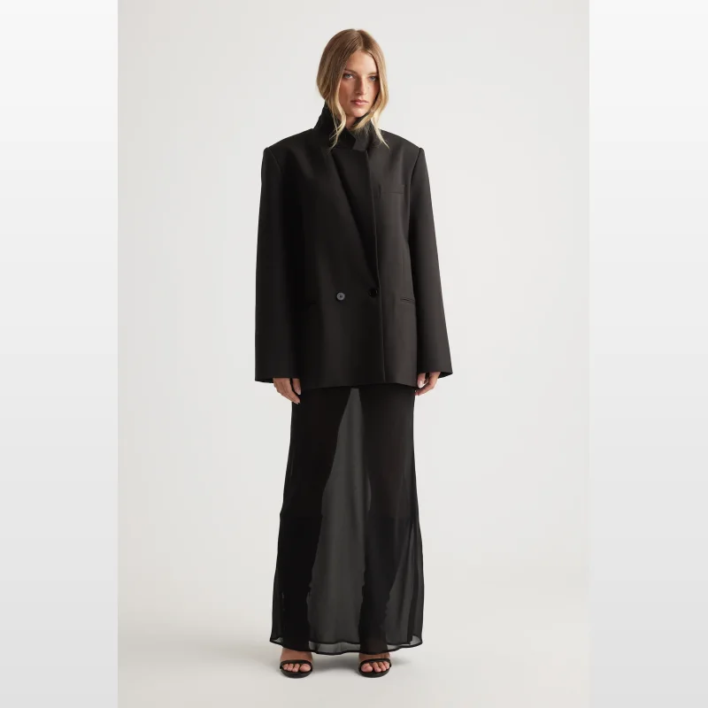 Model wearing a black sheer maxi skirt with an elasticated waistband.