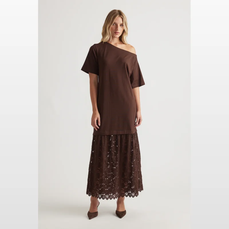Woman wearing a brown Alexis Lace Maxi Dress by Decjuba, featuring a spliced one-shoulder oversized tee bodice and a semi-sheer lace maxi skirt.