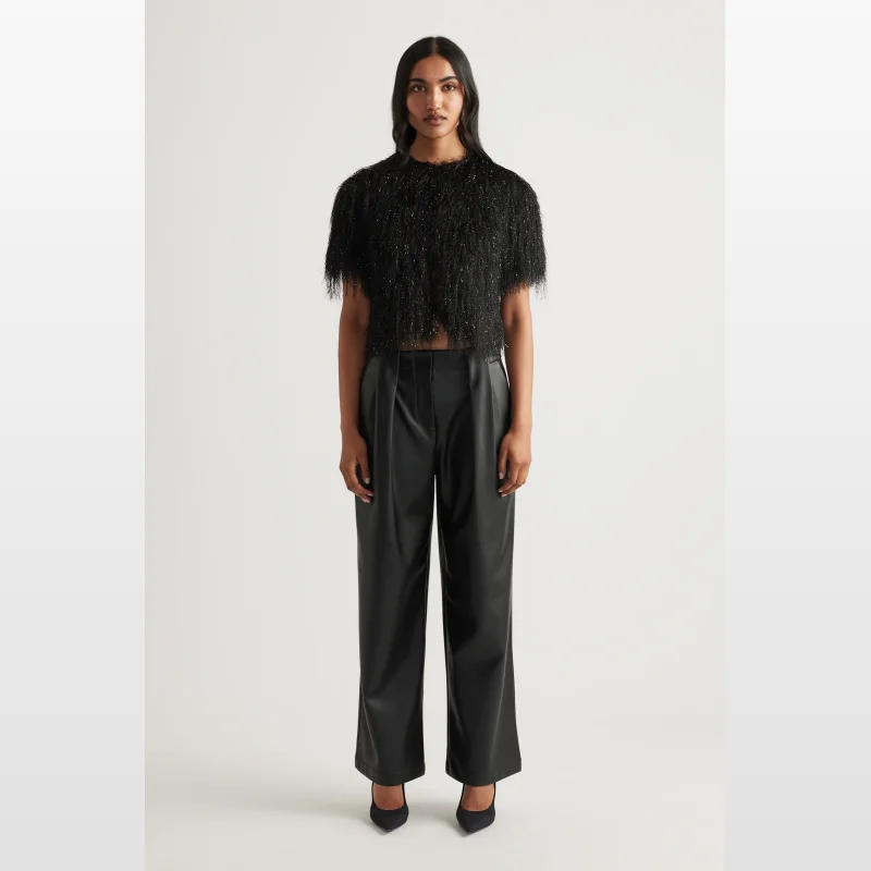 Woman wearing a black Decjuba Kenzie Fringe Lurex Cardigan with short sleeves, round neckline, and fringe detailing.