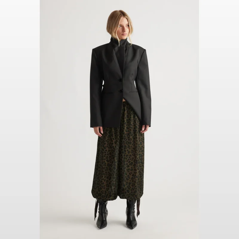 Woman wearing Decjuba Kiera Yoryu Balloon Pants with a leopard print in olive and black, featuring a cuffed hem with adjustable ties.