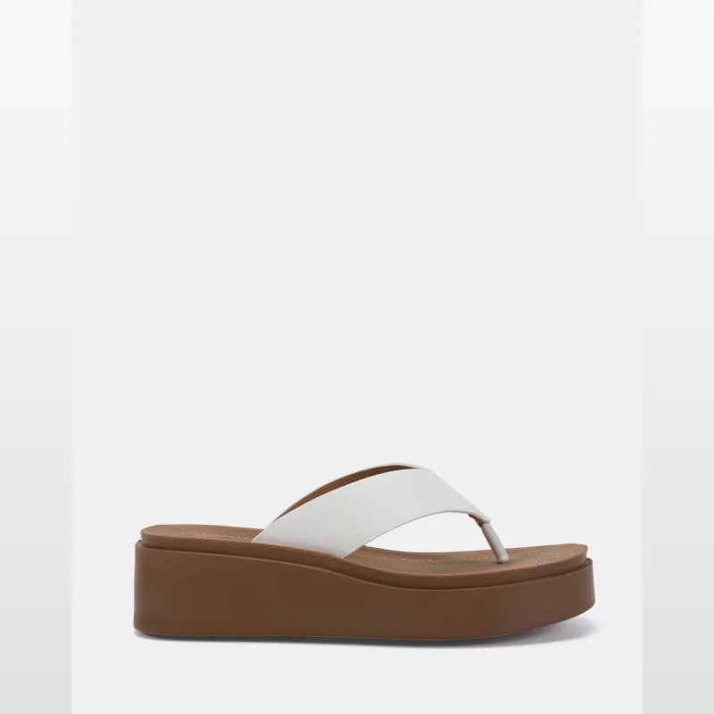 A white thong sandal with a wide upper strap and a thick brown platform sole, presented on a white background.