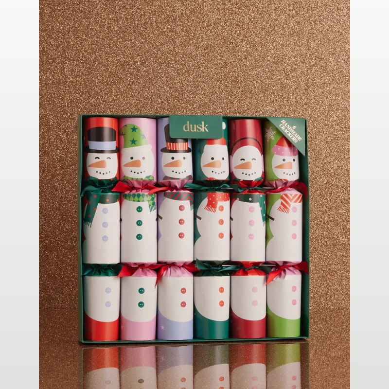 A box of six handmade Christmas crackers featuring various snowman designs, set against a sparkly bronze background.