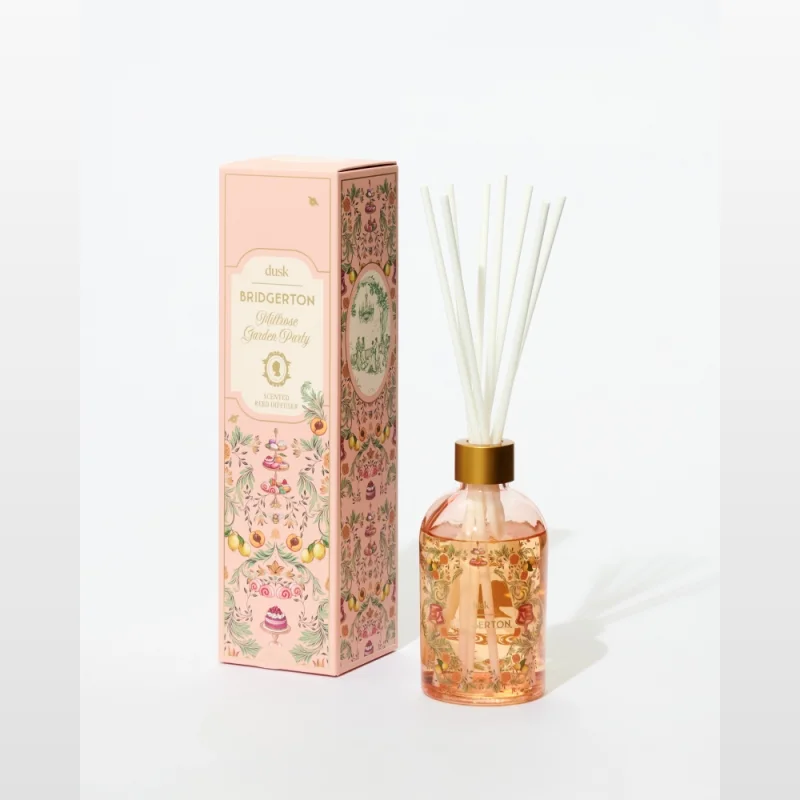 Dusk Millrose Garden Party Reed Diffuser 200mL with its decorative box, featuring a pink hue and intricate floral and fruit patterns.