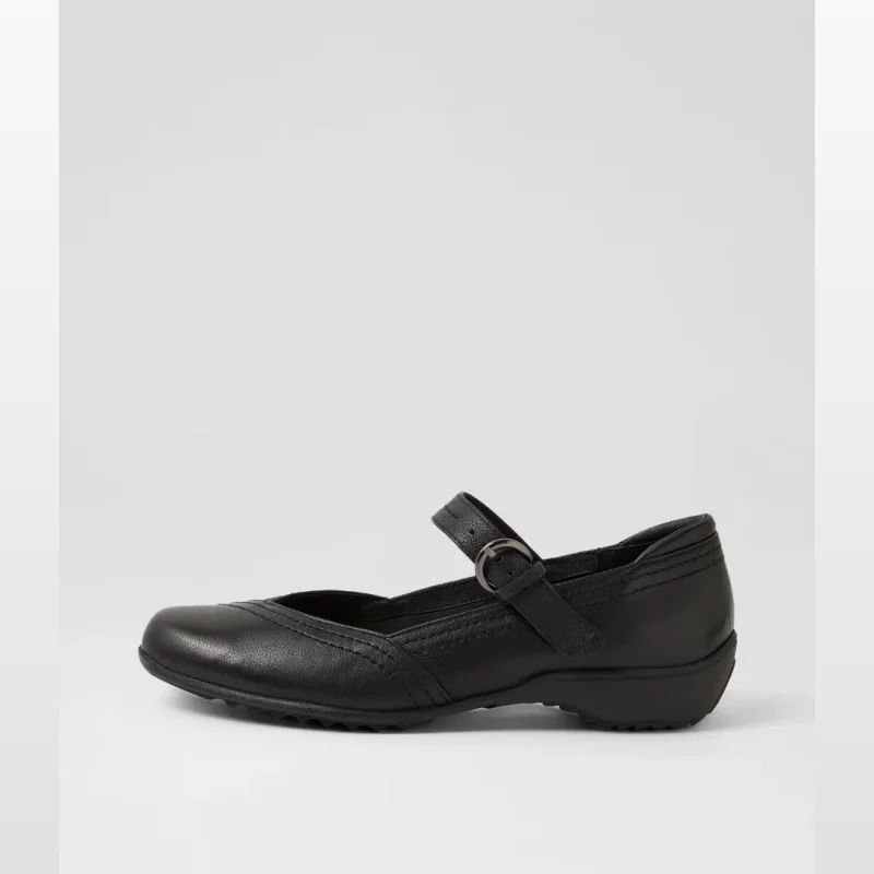 Side view of a black leather flat shoe with a single strap across the ankle featuring a buckle and riptape closure.