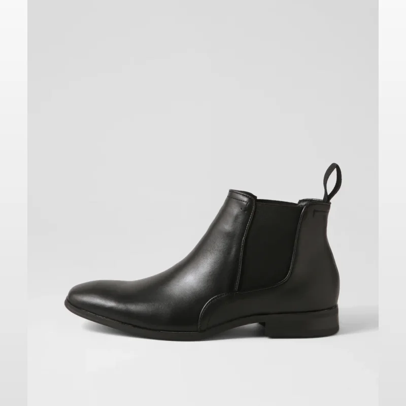 Side view of a black leather Chelsea boot with twin elastic gussets and a pull tab at the back.