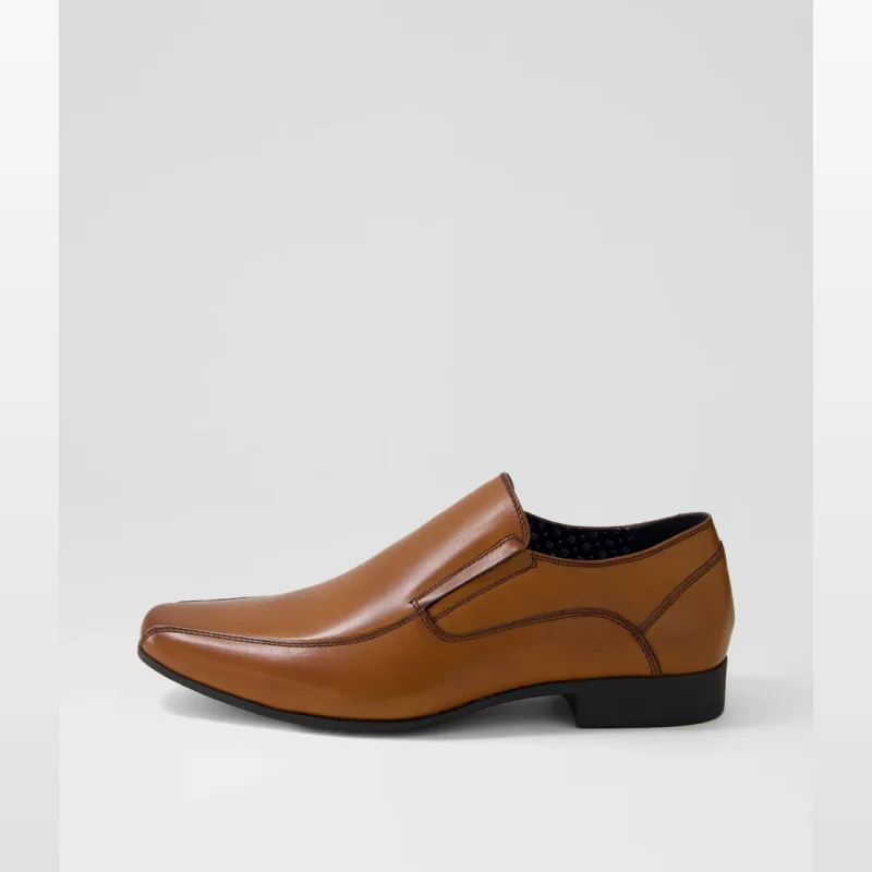 Side view of a single Wright Cognac Leather Loafer shoe, showcasing its pointed toe, slip-on design, and rich brown leather.