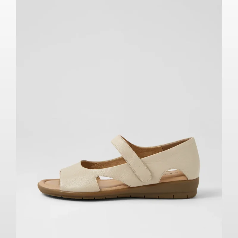 A side profile of a cream-coloured leather sandal with an almond-shaped peep toe and a single adjustable strap across the instep.