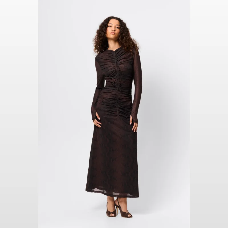 Woman wearing a long-sleeved, brown snake print mesh midi dress with ruching down the front and thumbholes.
