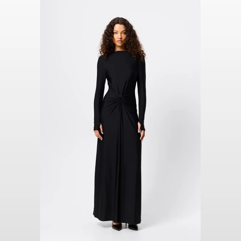 Woman wearing the Mossman Regal Maxi Dress in black, a long-sleeved A-line gown with a draped waist featuring a silver U-shaped metal detail and a boat neckline.
